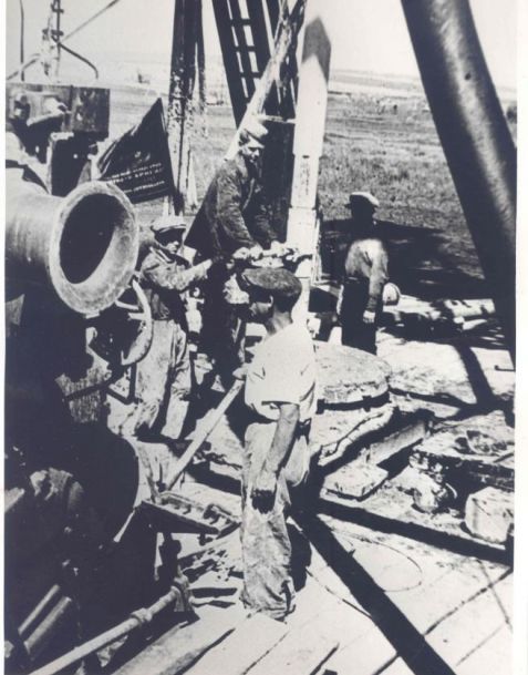 Молодежная фронтовая бригада бурильщиков на нефтепромыслах за бурением скважины на новом промысле, д. Кинзебулатово, 1944 г.